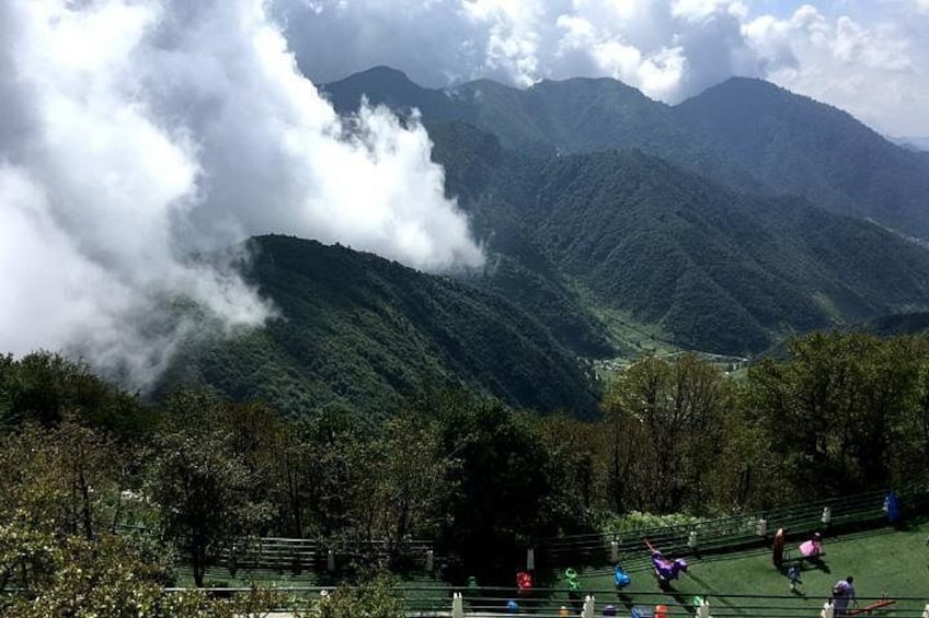 A mountainous landscape with a valley, a river, and people engaging in outdoor activities. 2