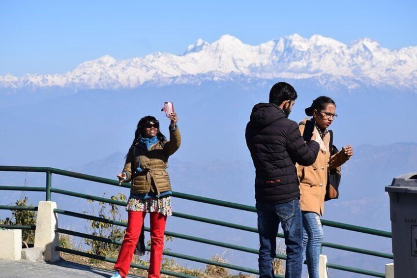 Three people taking a selfie with a mountain range in the background. 4