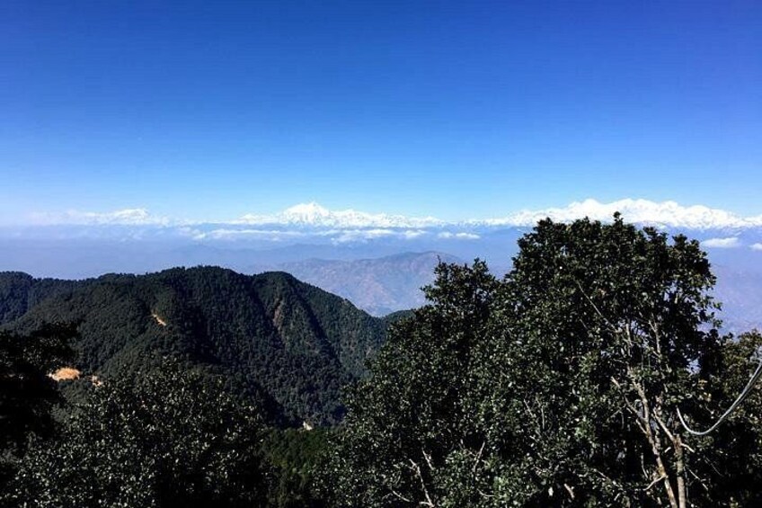 A mountainous landscape with dense forests and snow-capped peaks in the distance. 4