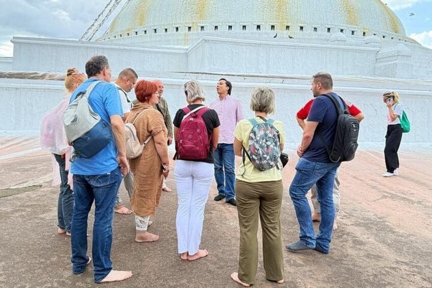A group of people standing in front of a large white building with a dome. 4