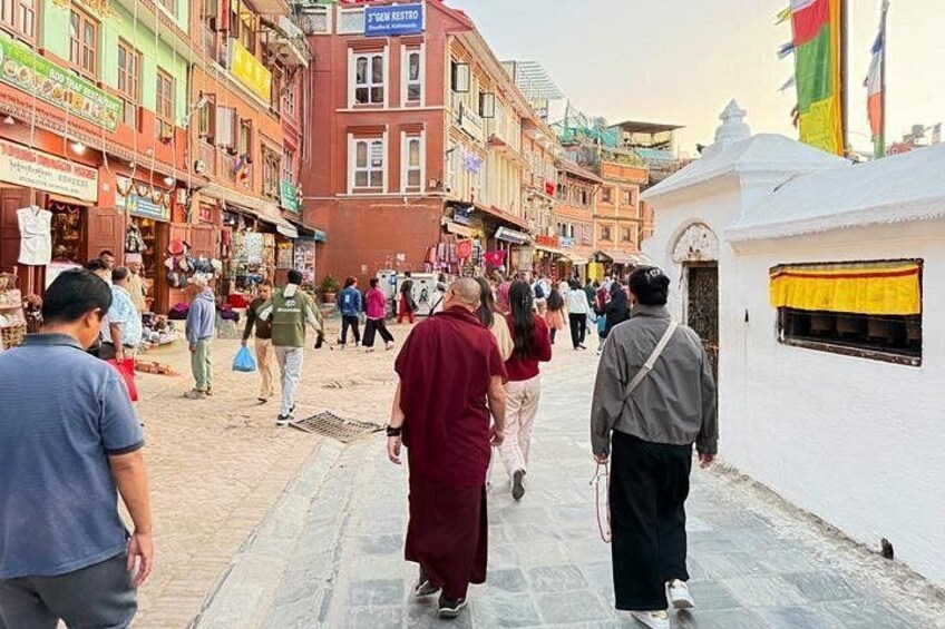 A busy street with people walking, shops, and colorful buildings. 2