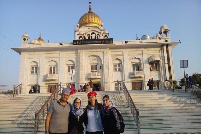 A group of people standing in front of a large white building with a golden dome. 5