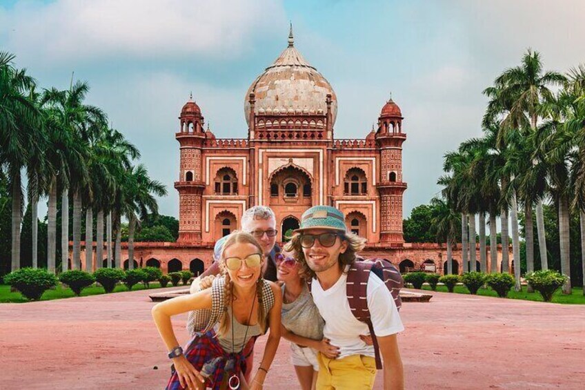 A group of people in front of a large, ornate building with a dome and minarets, surrounded by palm trees. 4