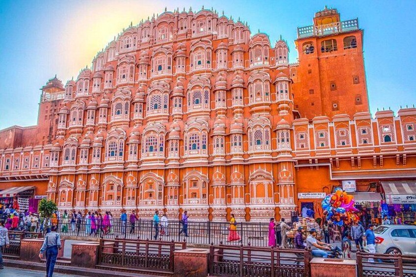 A large, ornate building with intricate architecture, a crowd of people, and a clear sky. 2