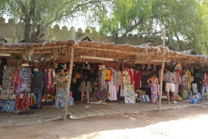 Ein Marktstand mit bunten Kleidungsstücken und Accessoires. 3