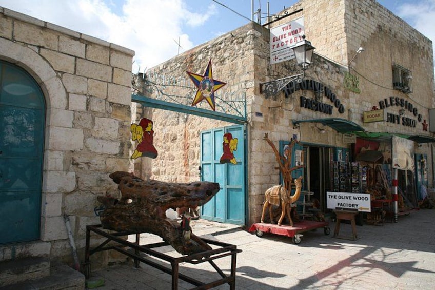 Un edificio de piedra con un letrero que dice 'The Olive Wood Factory' y una decoración con forma de estrella. 4