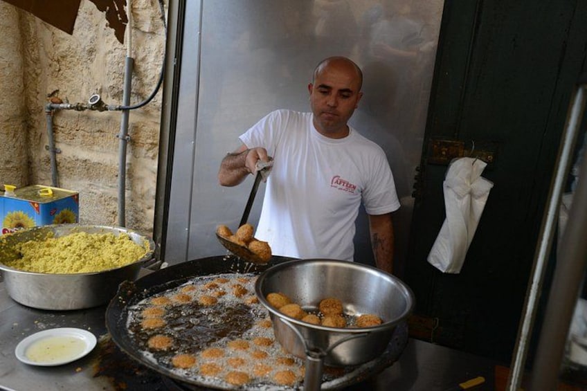 Una persona friendo comida en una sartén grande. 3