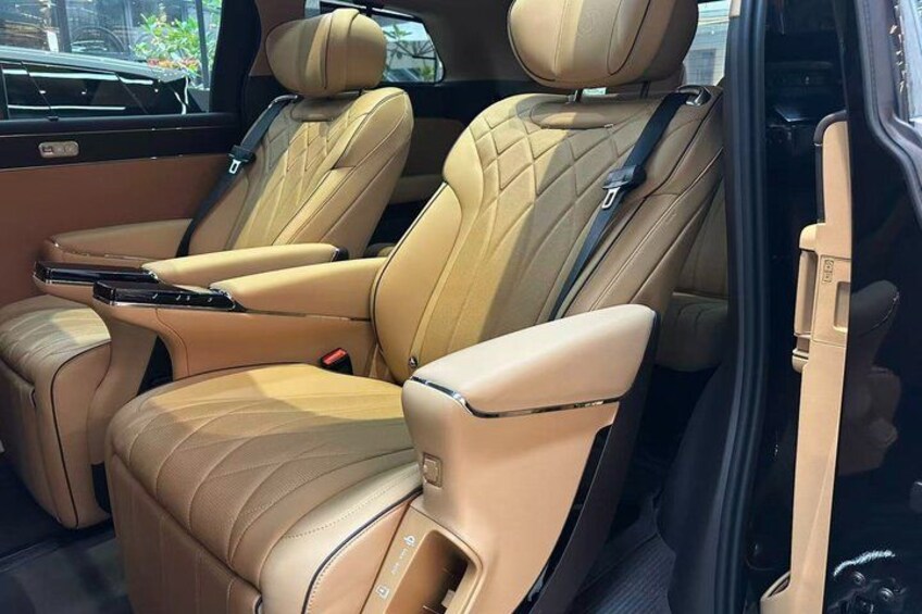 A car interior with beige leather seats and a sunroof. 3