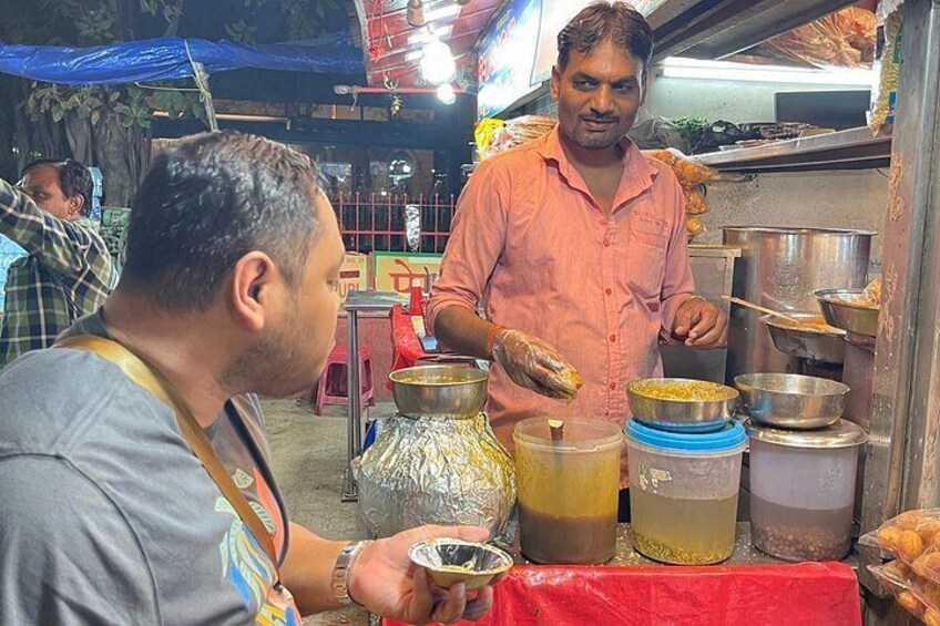 A street food vendor preparing food, with containers and cooking utensils visible. 3