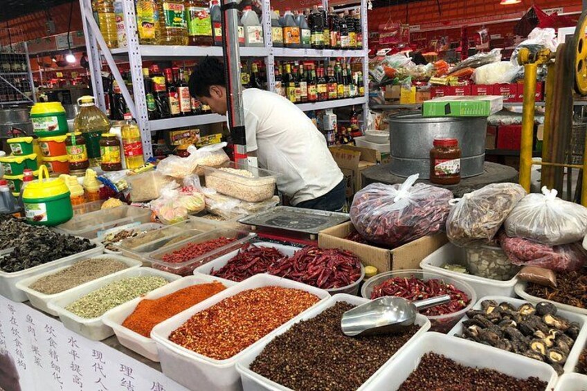 A market with various spices and condiments displayed in containers. 3