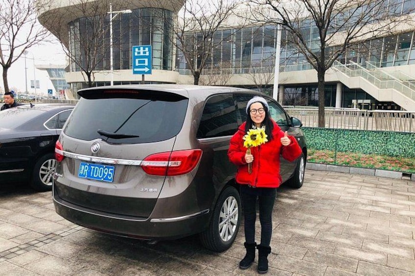 Una persona in piedi accanto a un'auto parcheggiata con una targa. 2
