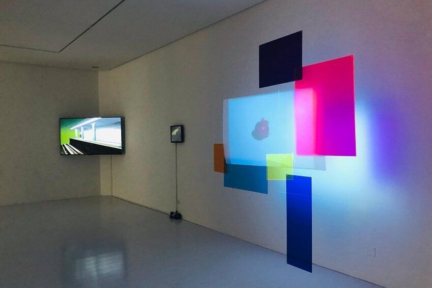 A modern art installation with geometric shapes and a television screen. 3