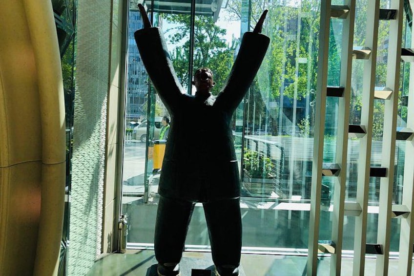 A person standing in front of a glass window with their arms raised. 4
