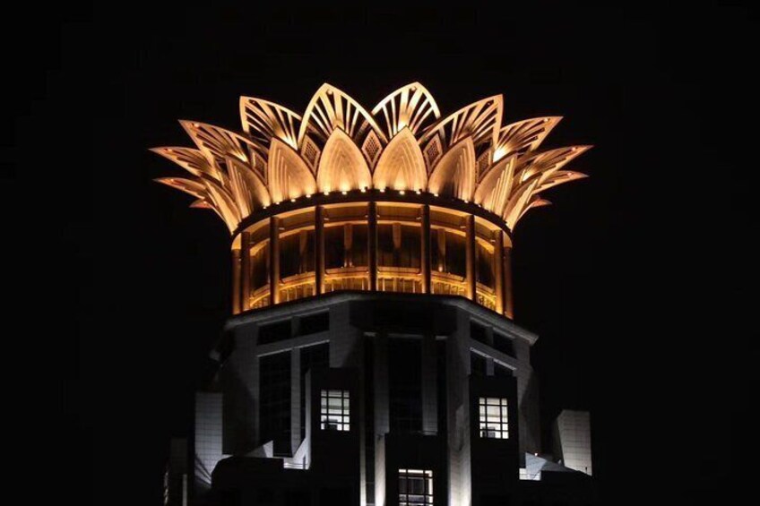 A brightly lit lotus-shaped structure at night. 4