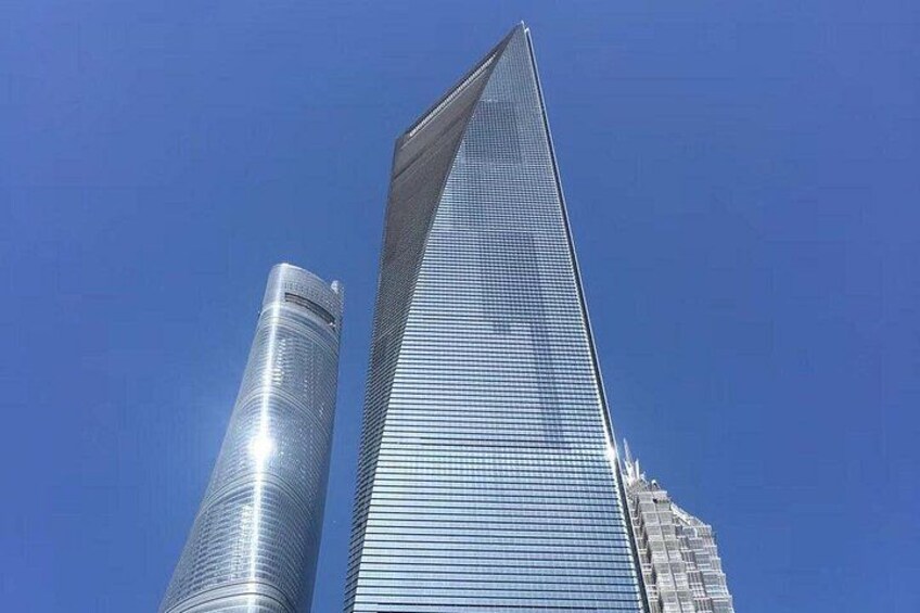 Two tall buildings with reflective glass facades against a clear blue sky. 4