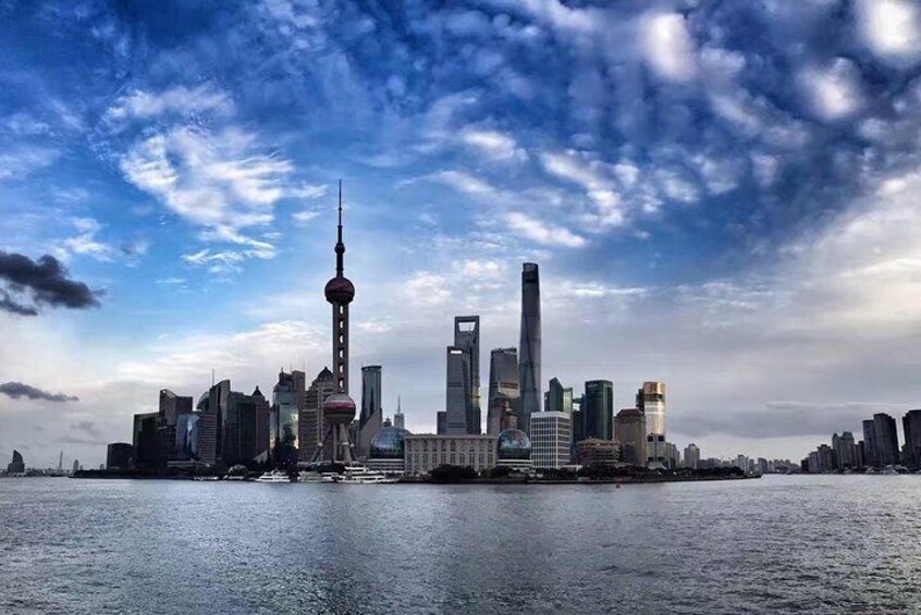 A city skyline with a prominent tower and several modern buildings along a waterfront. 1