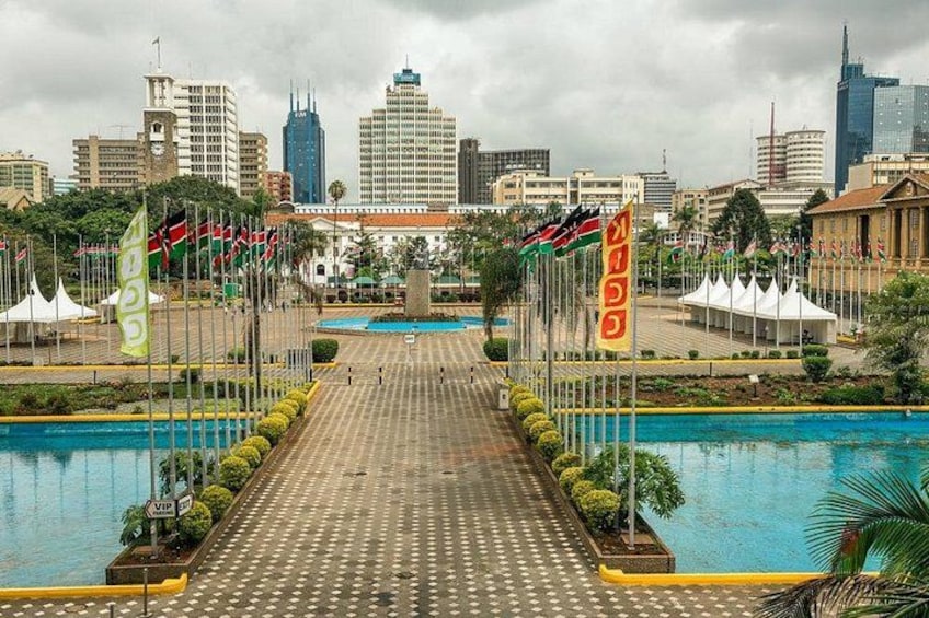 A cityscape with a large pool, a bridge, and multiple flags. 4