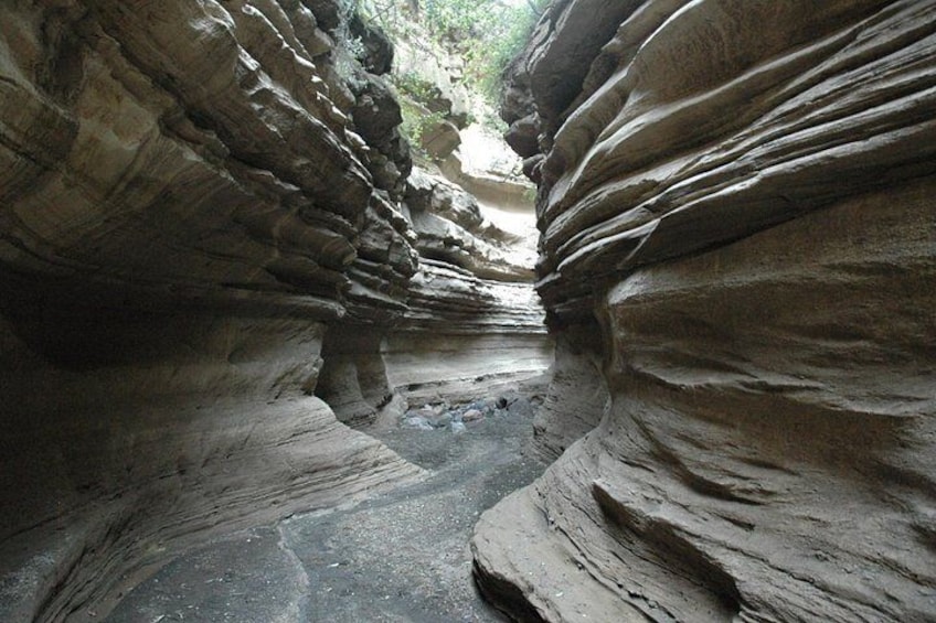 A narrow canyon with layered rock formations. 2