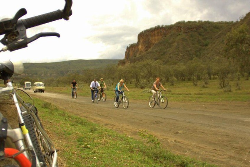 A dirt road with cyclists and a parked bicycle. 3