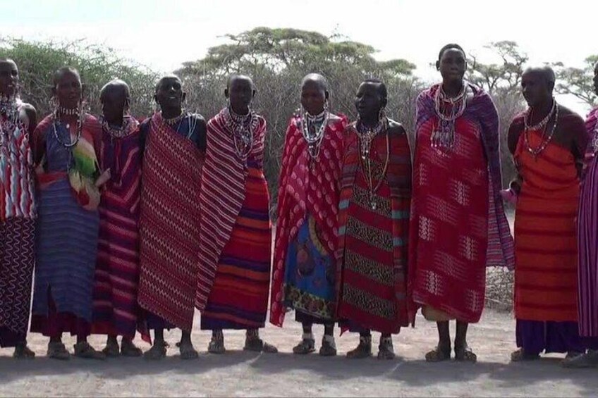 A group of people in traditional attire standing outdoors. 5