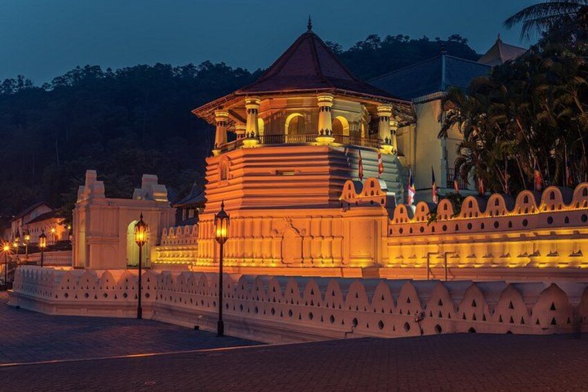 A well-lit temple with a dome roof, surrounded by a white wall with decorative elements. 4
