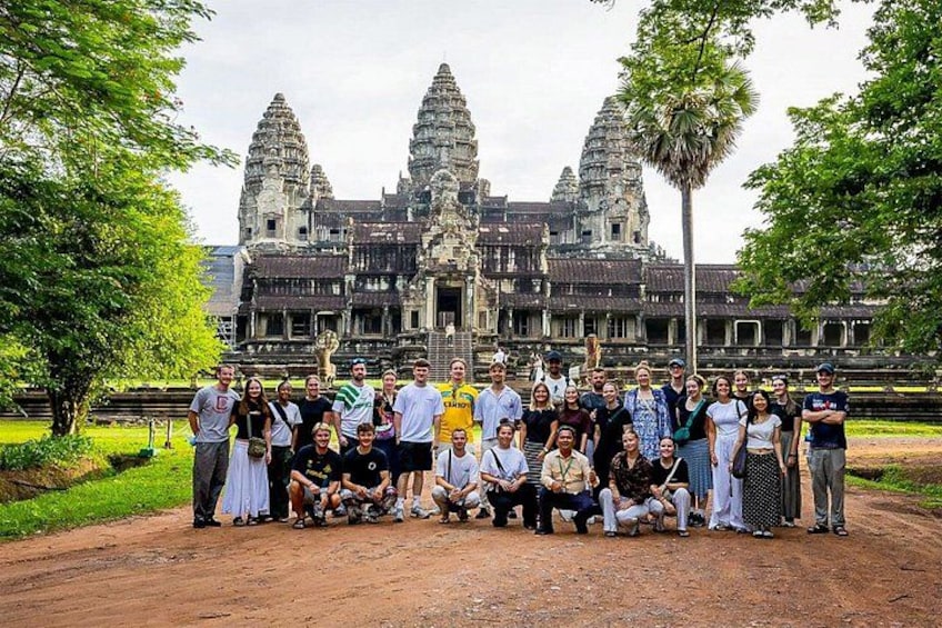 A group of people posing in front of Angkor Wat temple. 5