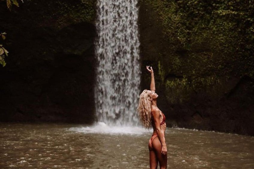Una cascata, una persona in costume da bagno e una zona boschiva. 4
