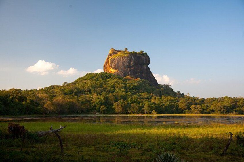 Une grande formation rocheuse, entourée d’une végétation luxuriante et bordée d’une étendue d’eau calme. 2