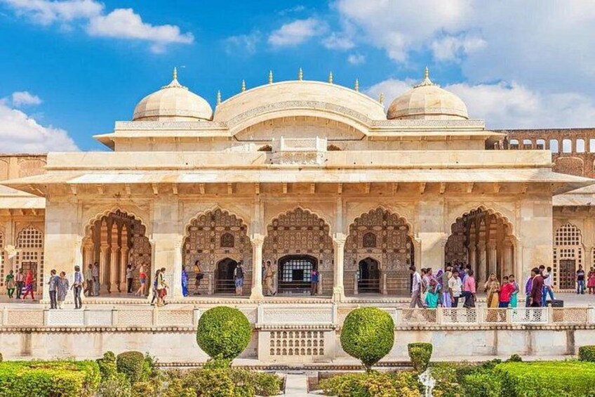 A historic building with arches and domes, surrounded by a well-maintained garden. 4
