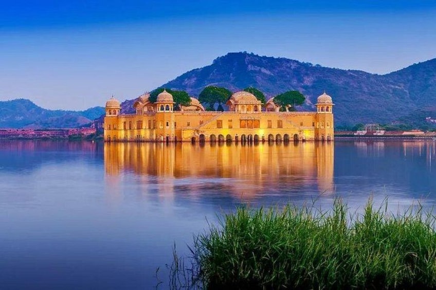 A palace by a calm lake with mountains in the background. 5