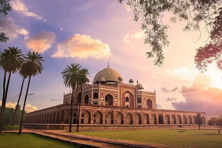 A large, historic building with a dome and arched windows, surrounded by palm trees and a clear sky. 2