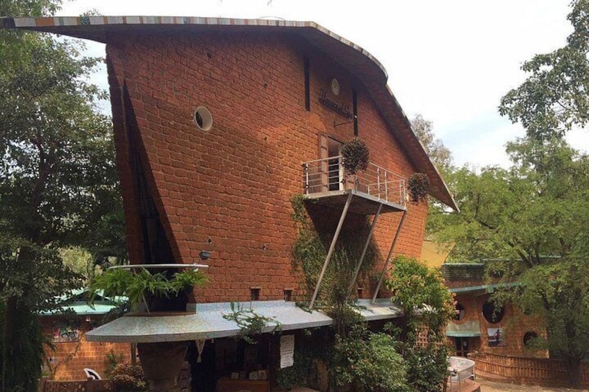 Ein Backsteinhaus mit einem markanten, gewölbten Dach und einem kleinen Balkon. 3