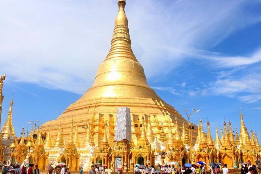 A large golden stupa surrounded by smaller golden structures, with a crowd of people in front. 5