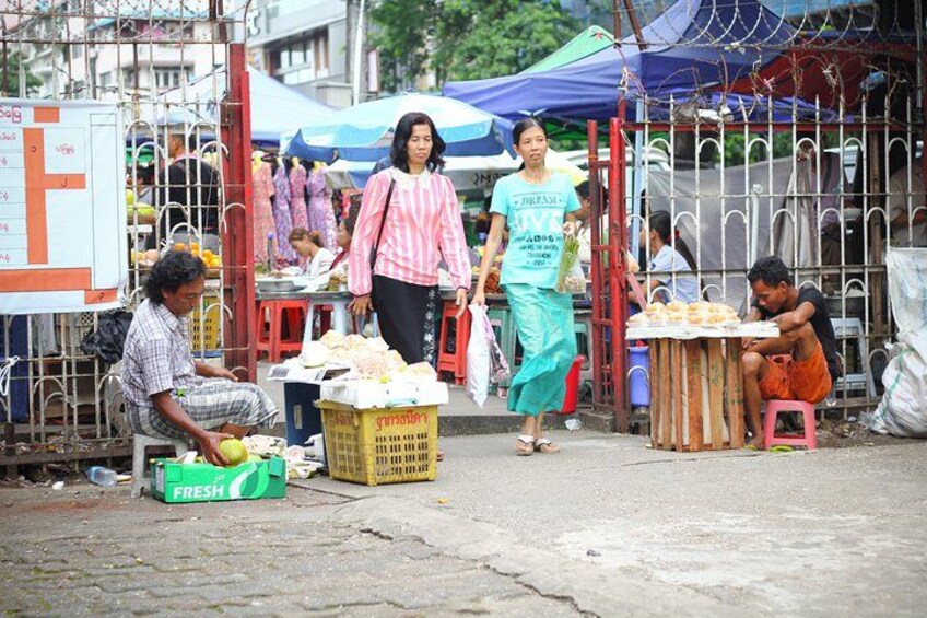 A street market with people walking and vendors selling goods. 3