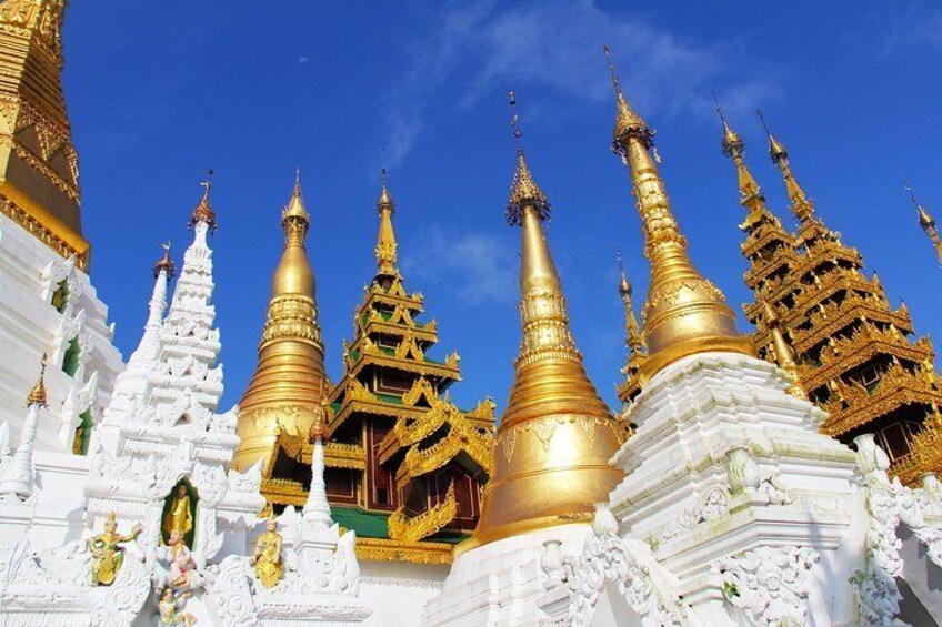 Golden pagodas with intricate designs and white structures. 1