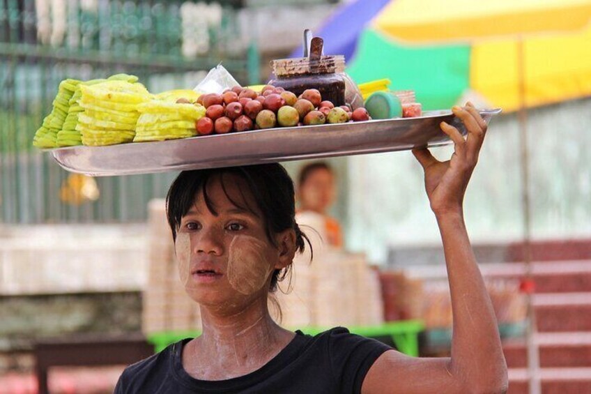 A person carrying a tray with various fruits and vegetables. 3