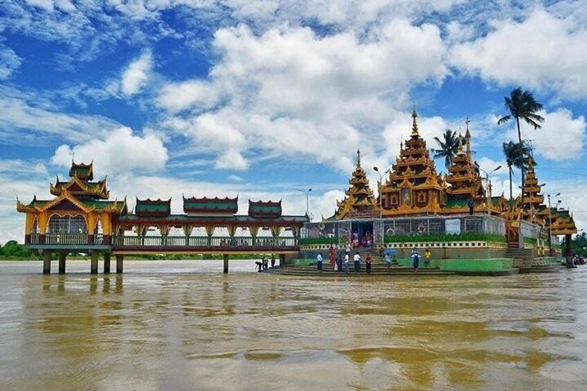 A temple complex with golden spires and a reflective water surface in the foreground. 1