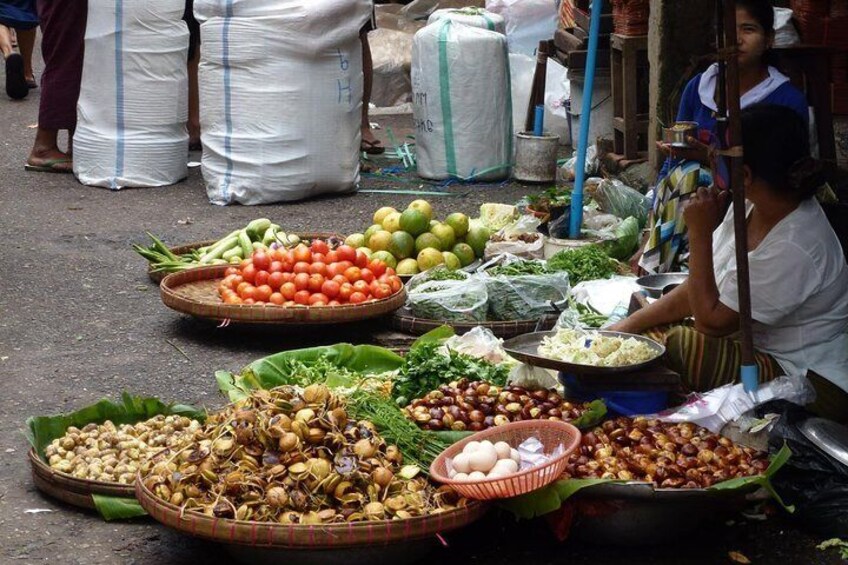 A street market with various vegetables and fruits displayed on trays and baskets. 5