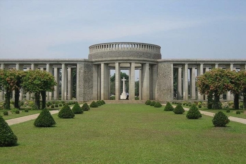 A large, circular building with a central open area, surrounded by a symmetrical garden with trimmed hedges and trees. 4