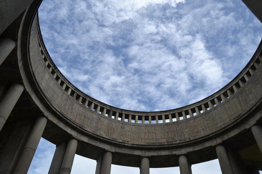 A circular architectural structure with columns and a sky view. 3