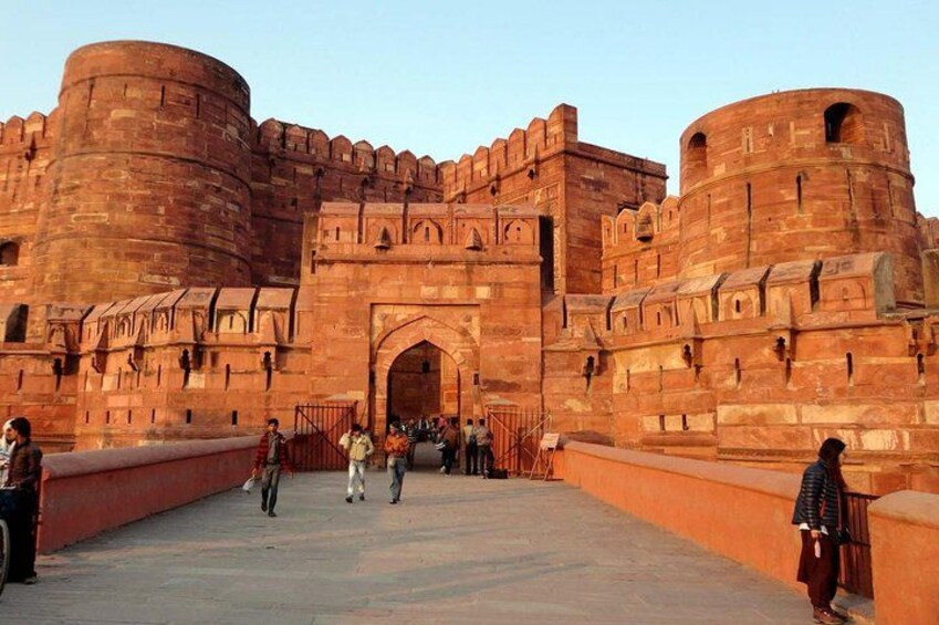 A large, historic red brick fort with multiple towers and a central archway. 3