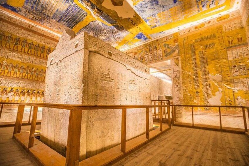 En forntida egyptisk sarkofag med hieroglyfer, omgiven av väggar med liknande ristningar. 1