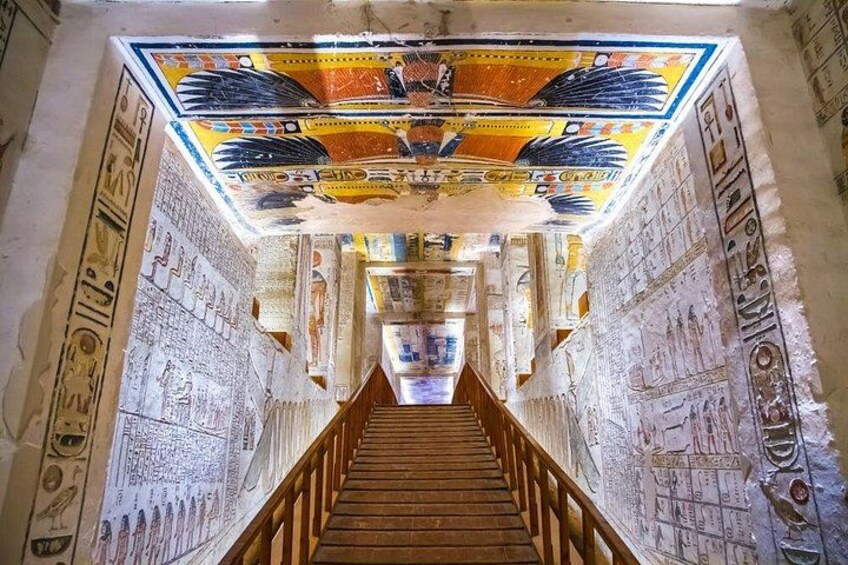 En korridor med hieroglyfer på väggarna och ett färgglatt tak. 4