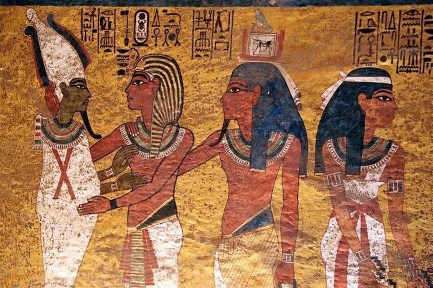 Une fresque représentant trois personnages vêtus de costumes de l’Égypte ancienne, des hiéroglyphes et un oiseau sur un couvre-chef. 3