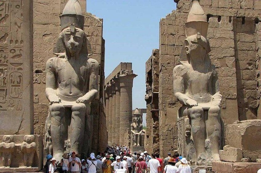 Estatuas egipcias antiguas en un templo, con jeroglíficos en las paredes. 2