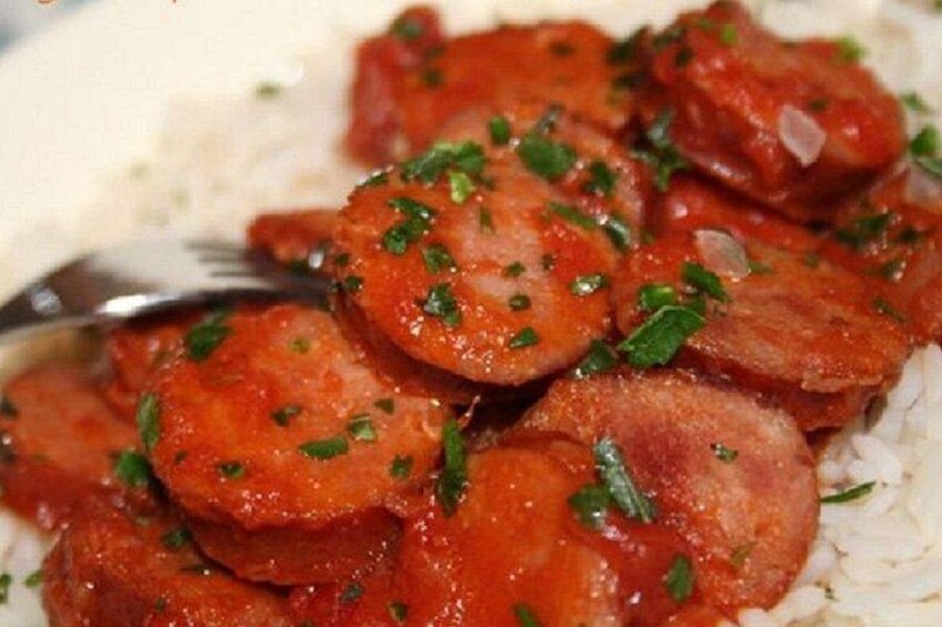 Sliced sausage garnished with herbs on a bed of rice. 2