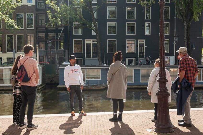 People standing by a canal with buildings in the background. 1