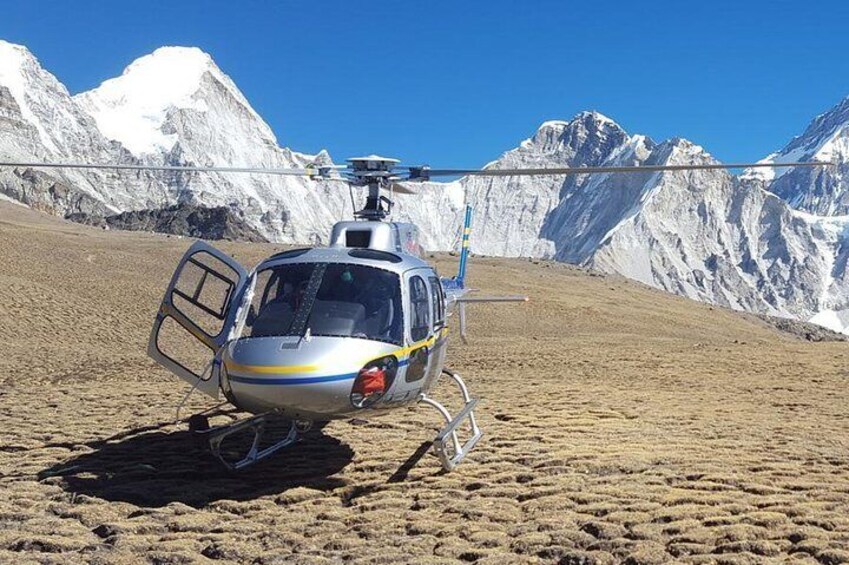 Un hélicoptère est garé sur une montagne enneigée, avec un ciel bleu dégagé en arrière-plan. 4