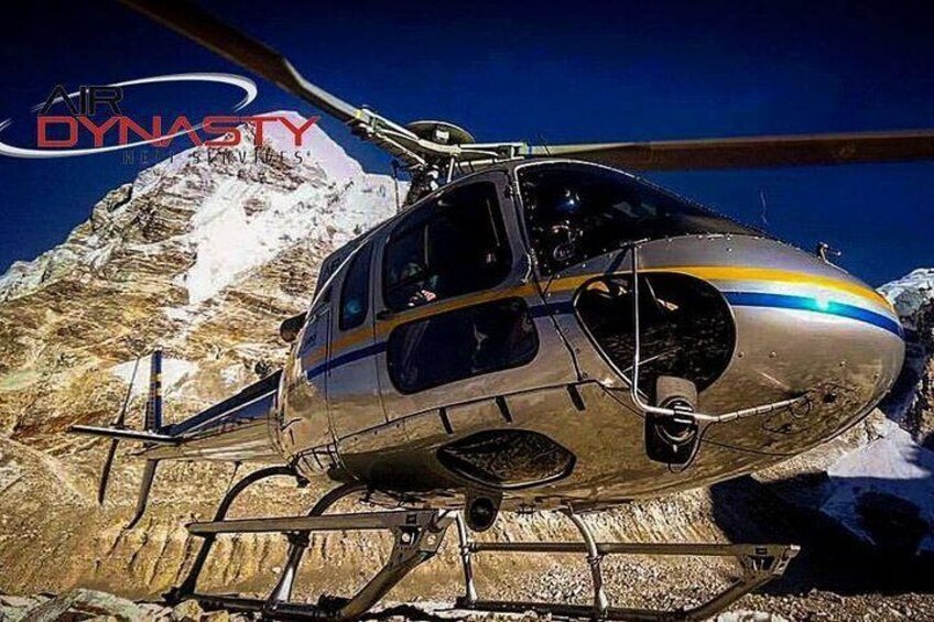 Un hélicoptère orné d’une bande jaune et bleue est garé sur une montagne enneigée. 5