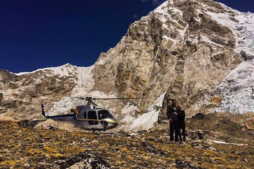 Un hélicoptère est garé sur un terrain rocheux, avec une montagne en arrière-plan. 3